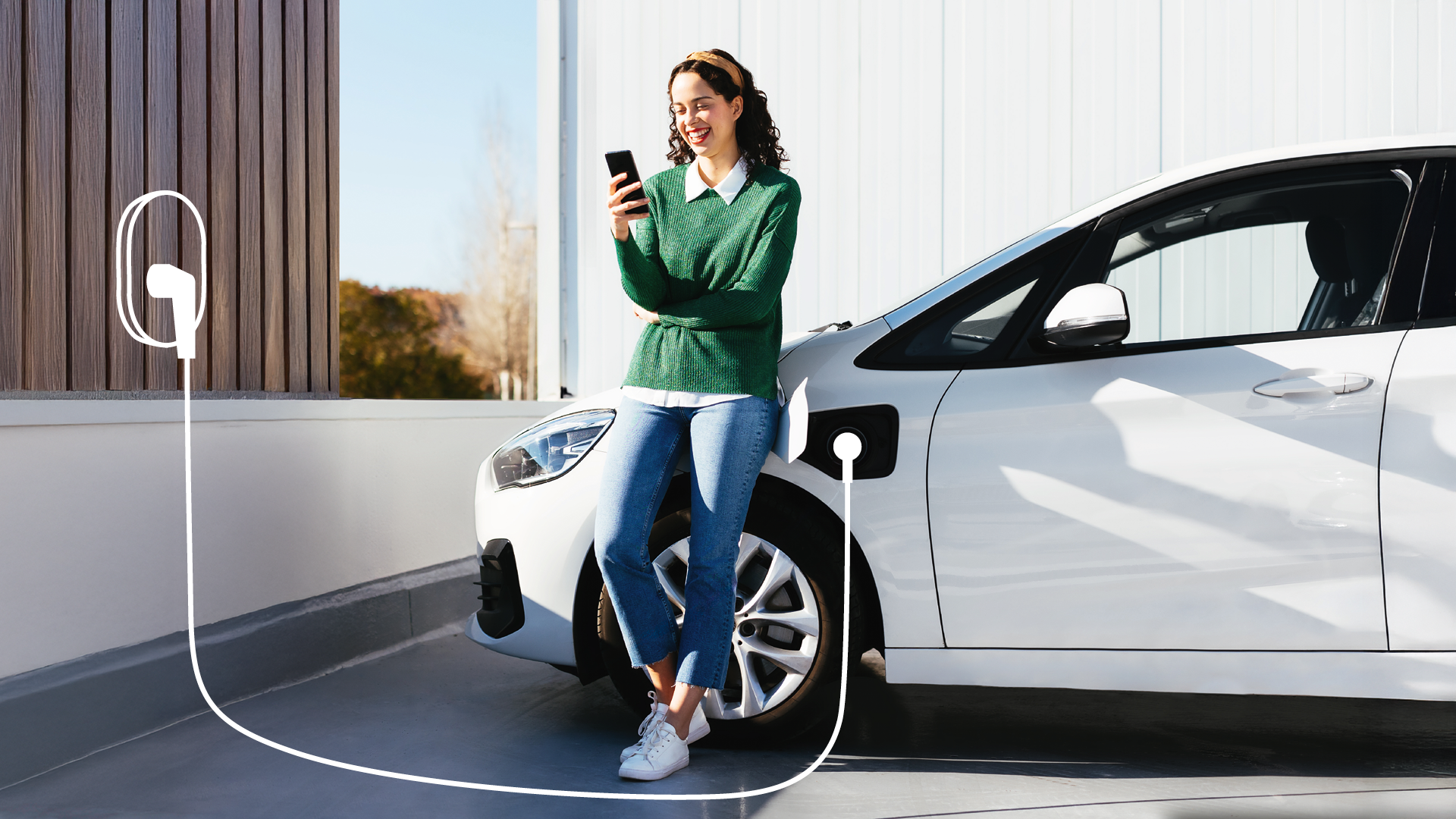 Frau lehnt an Elektroauto und lädt es über die Ladebox